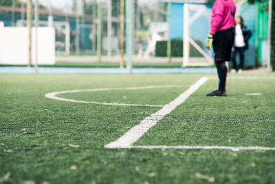 Low section of male goalie standing on soccer field