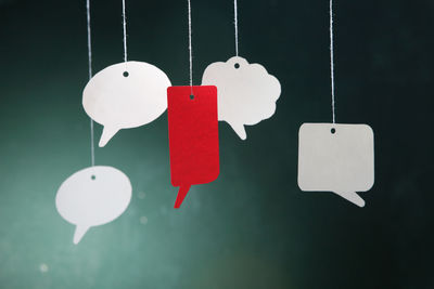 Close-up of speech bubbles hanging against wall