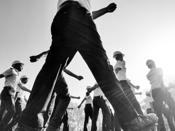 Low angle view of people standing against clear sky