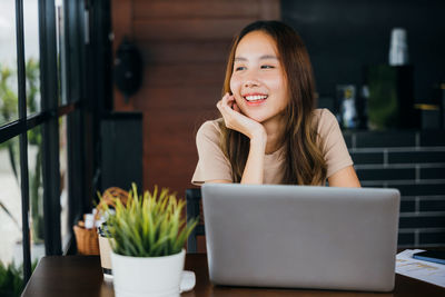 Young woman using laptop while sitting at home