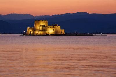 Scenic view of sea against sky during sunset, with the bourtzi fortress against the mountain