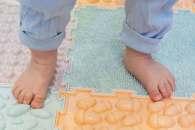 Toddler baby foots on a medical orthopedic colorful massage mat.