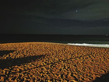 Scenic view of beach against sky at night