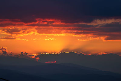 Scenic view of silhouette mountains against romantic sky