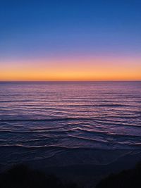 Scenic view of sea against clear sky during sunset