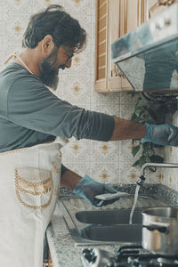 Side view of man preparing food in kitchen