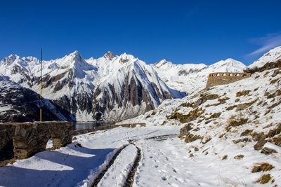 Scenic view of snowcapped mountains against blue sky