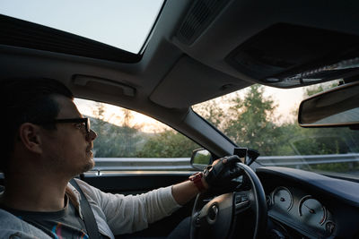 Man driving luxury car at sunset