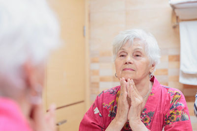 Mature woman taking care of her face