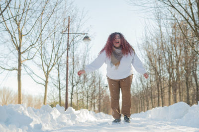 Portrait of young woman standing on snow covered landscape