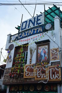Low angle view of text on building against sky
