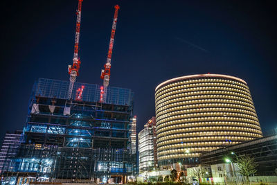 Low angle view of illuminated buildings against sky at night