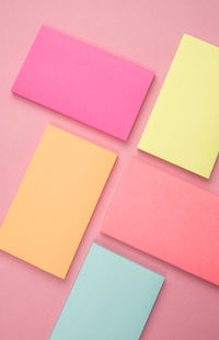 High angle view of colorful adhesive notes on pink background