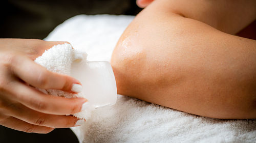 Ice massage for painful elbow. hands of a therapist placing ice directly 