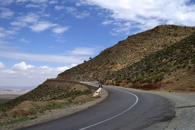 Road by mountain against sky