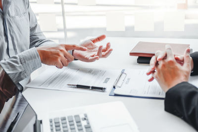 Midsection of business colleagues working at table