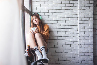 Portrait of woman sitting on wall