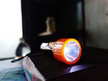 Close-up of illuminated lamp on table