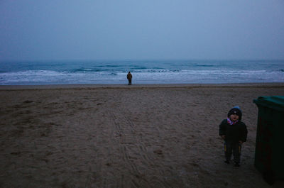 People on beach against clear sky