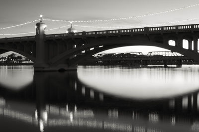 Reflection of bridge in river at dusk