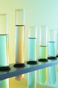 Close-up of test tubes in rack against colored background