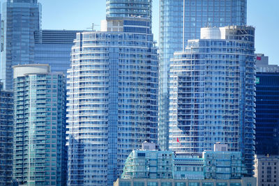 Modern buildings in city against blue sky