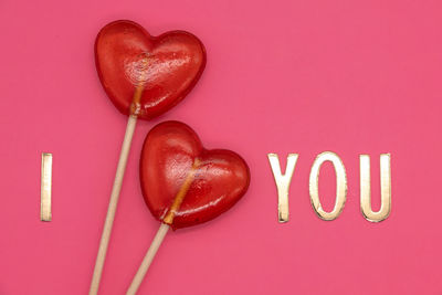 Close-up of heart shape over pink background