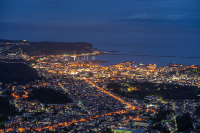 High angle view of illuminated city against sky at night