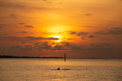 Scenic view of sea against orange sky