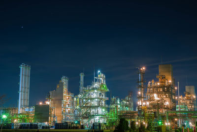 Illuminated buildings against sky at night