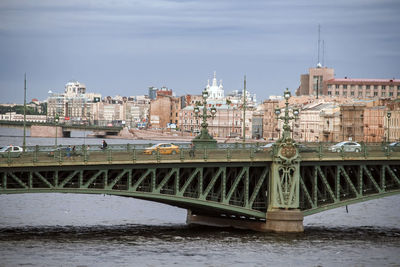 Bridge over river against buildings in city