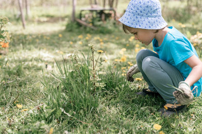 Side view of boy sitting on grass