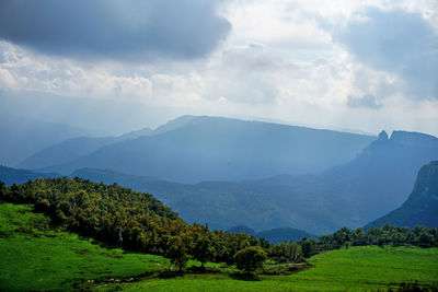 Scenic view of mountains against cloudy sky