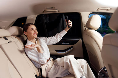 Portrait of smiling young woman sitting in car