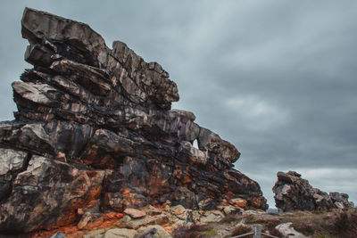 Low angle view of rock formation against sky