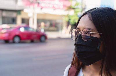 Portrait of woman with umbrella on street in city