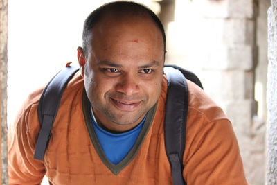 Close-up of smiling man looking away while standing outdoors