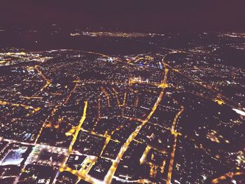 High angle view of illuminated city against sky at night