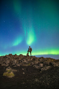 Low angle view of man standing on mountain at night