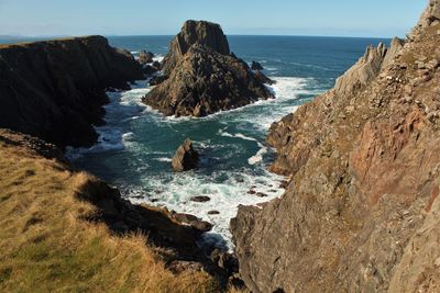 Scenic view of rocks on beach against sky