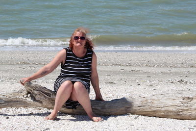 Portrait of smiling young woman sitting on beach