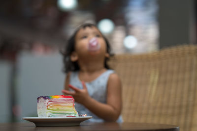 Close-up of cake on table with girl in background