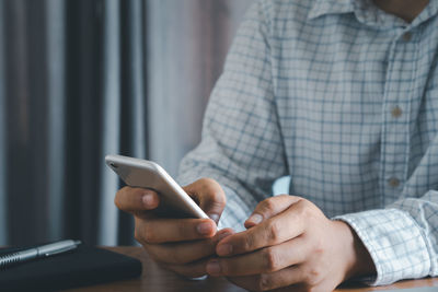 Midsection of man using mobile phone