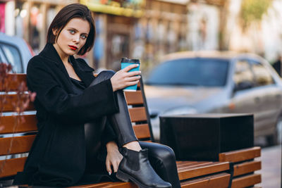 Young woman using mobile phone while sitting in bus