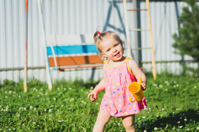 Portrait of girl standing on grassy field