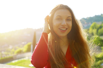 Portrait of smiling young woman standing in park