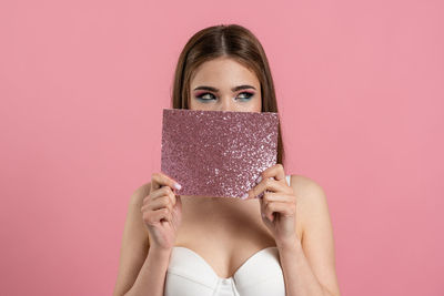 Portrait of woman with pink face against gray background