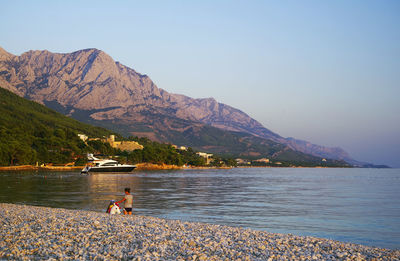 Scenic view of lake by mountains against sky