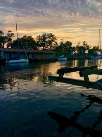 Scenic view of swimming pool by lake against sky during sunset