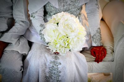 Low section of woman holding bouquet